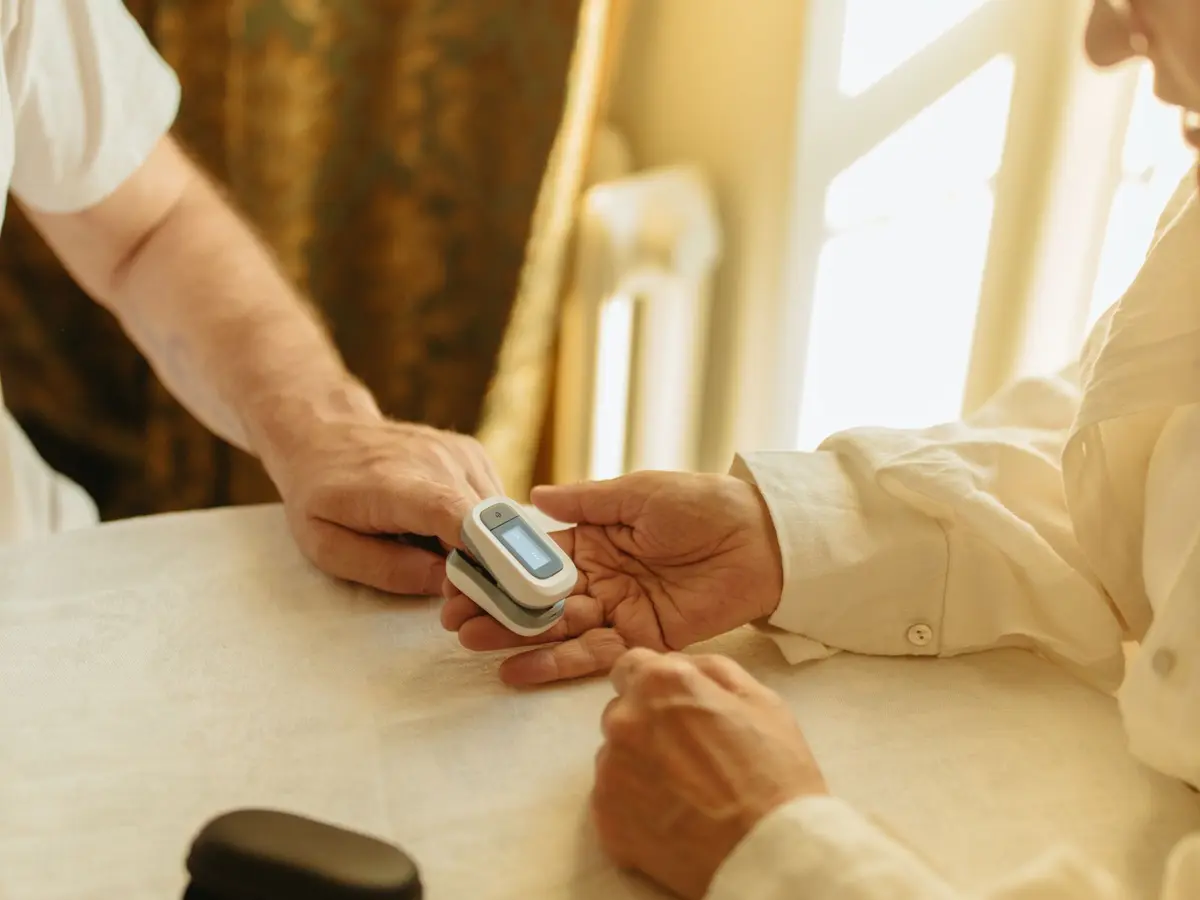 A pulse oximeter clipped to an elderly patient’s finger