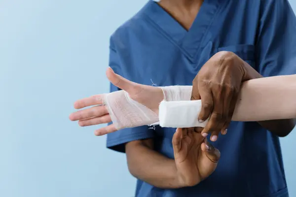 A nurse wrapping a clean bandage around a patient’s hand