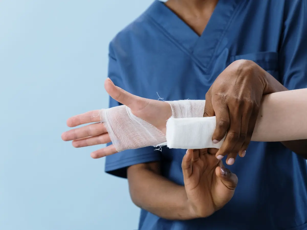 A nurse wrapping a clean bandage around a patient’s hand